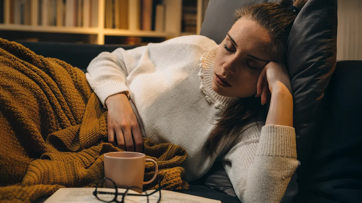 A woman fell asleep while reading in a cozy room